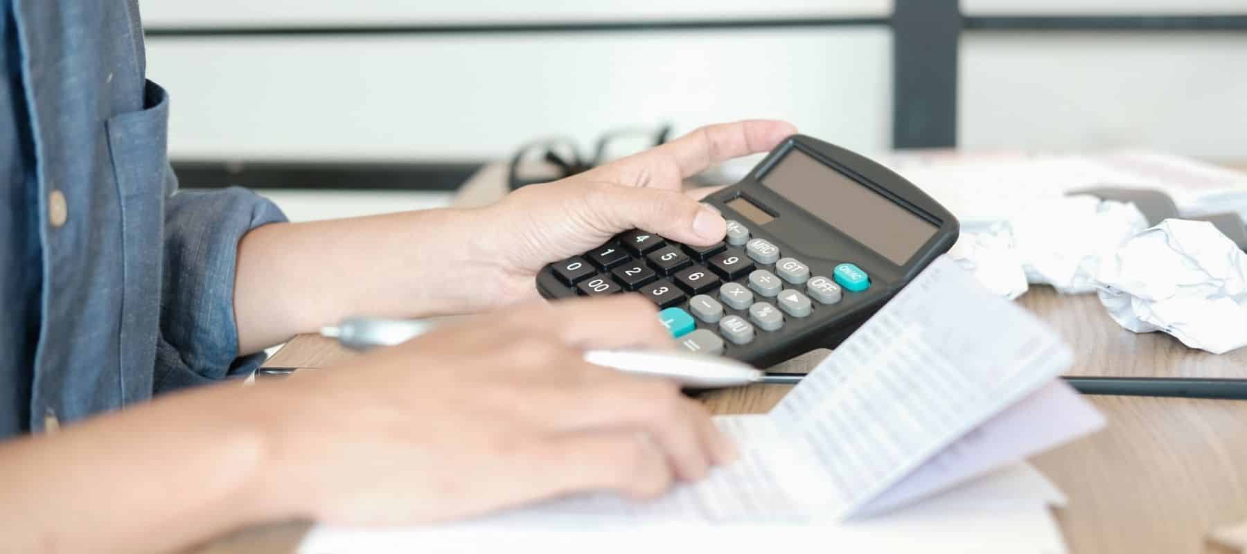 person using a calculator to get their finances