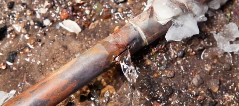 Frozen pipe with water leakage visible.